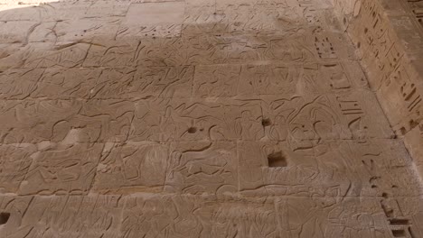 Wall-reliefs-and-ancient-Egyptian-inscriptions---Medinet-Habu,-Luxor,-Egypt