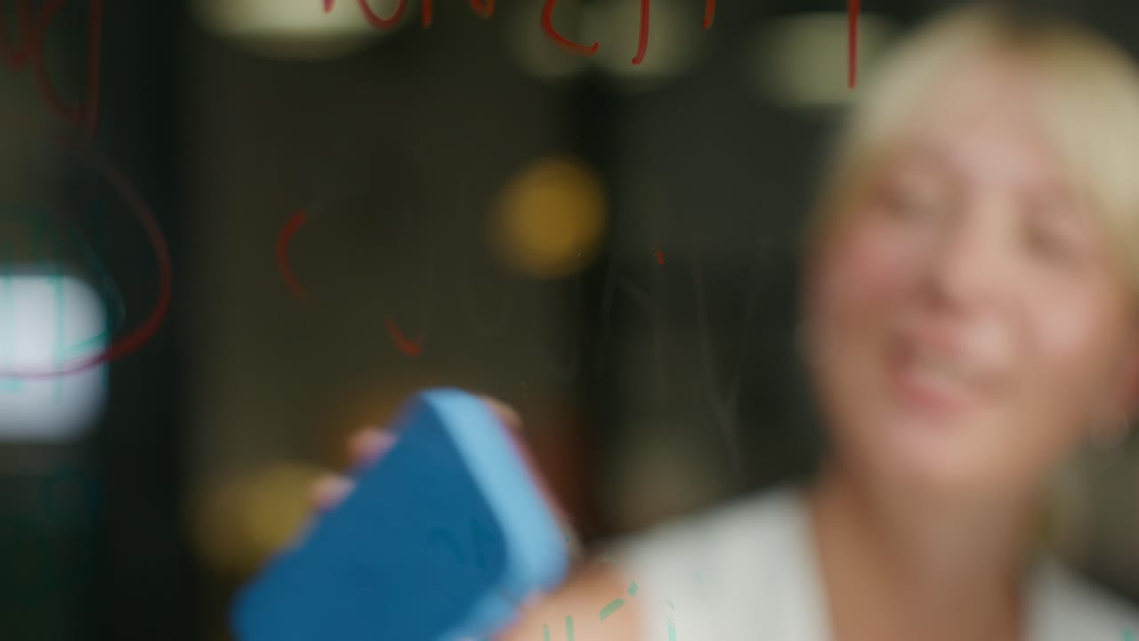 유리판 에서 메모 를 지우고 있는 여자