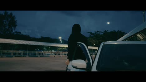person near car at night parking lot