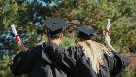 graduates congratulate each other on graduating from college hugging