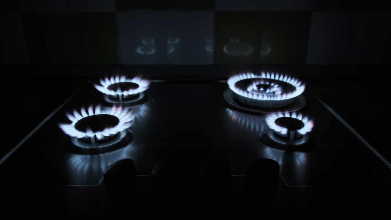 네 개의 가스 버너가 어 속에서 가스 스토브에서 동시에 불타고 있습니다.
