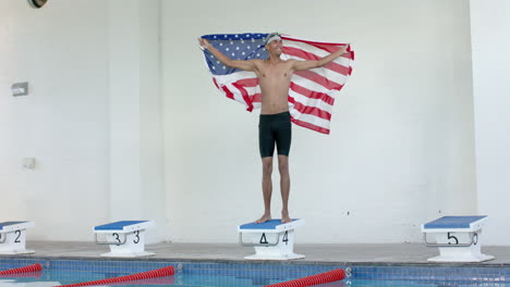 young biracial male athlete swimmer stands proudly with an american flag