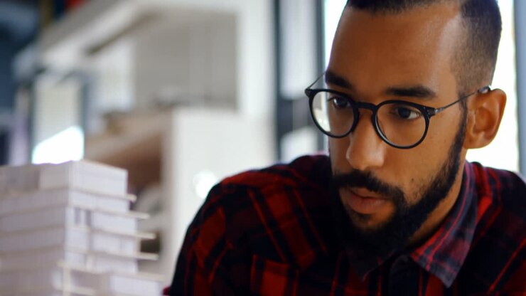Male architect looking at building model 4k