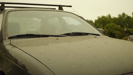 car hood and windshield covered in ash