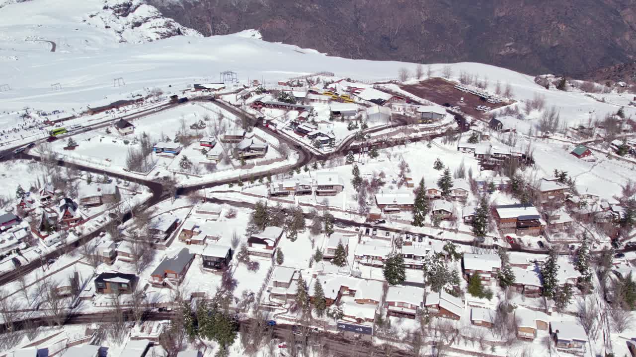 Aerial view establishing the mountain village of Farellones with European style chalets and cabins, full of snow, Chile's tourist attraction