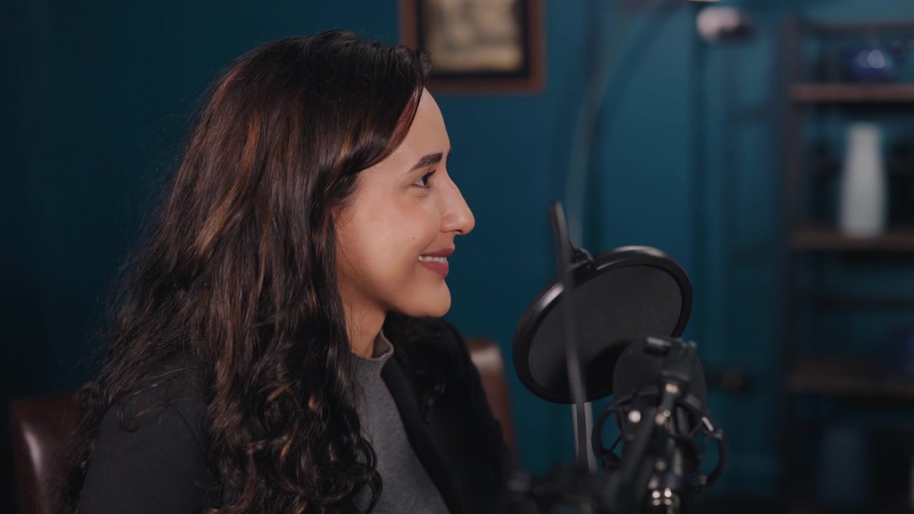Giovane donna che parla al microfono in un ambiente di studio professionale