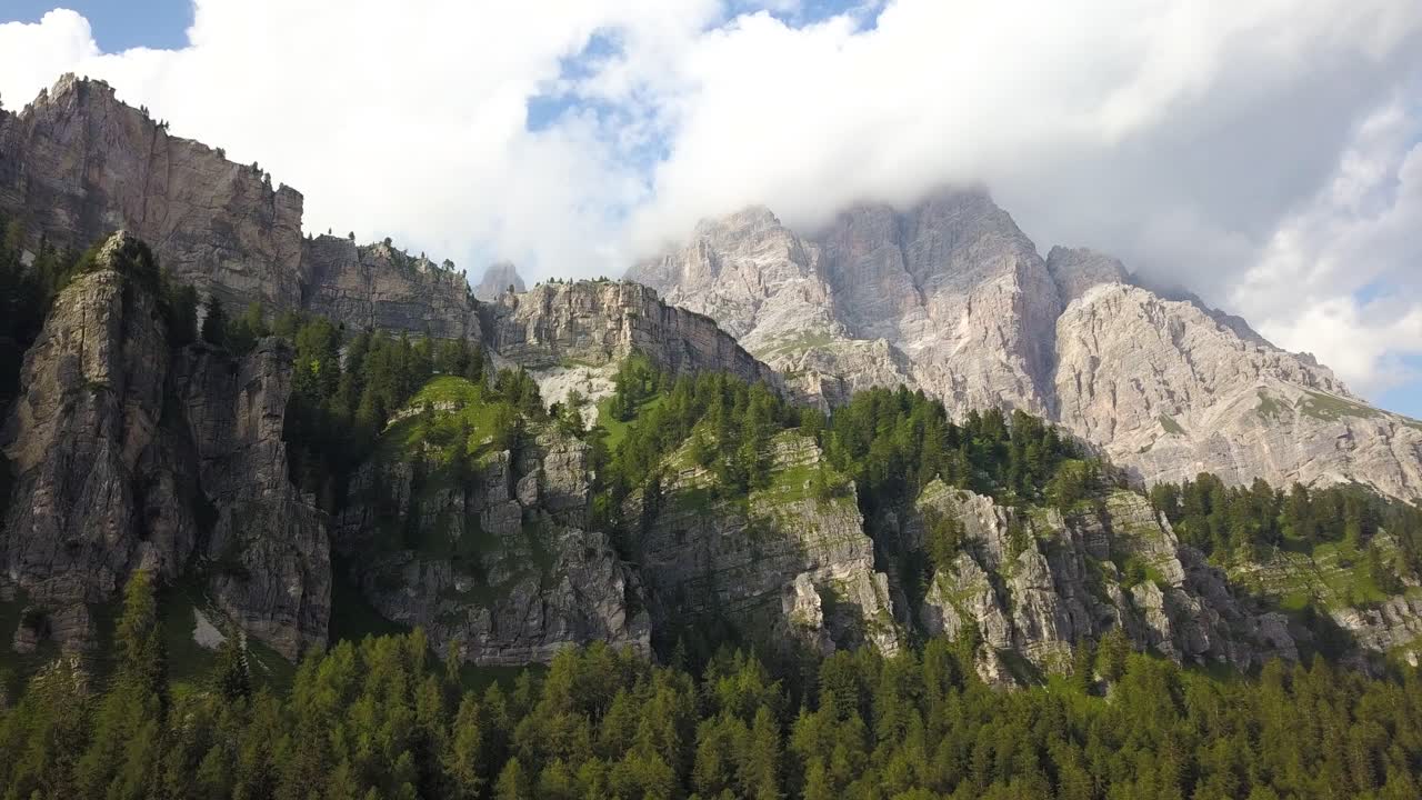 Moving up a mountain cliffside, green lush forest on a hillside, Tre cime, Belluno, Italia