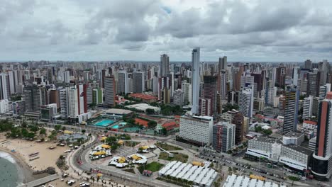 aerial: fortaleza cityscape with high rises and skyscrapers during the day in the state capital of ceara, located in northeastern brazil, orbit drone shot