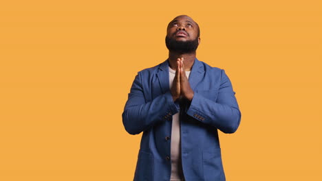 man praying to his god, asking for forgiveness, studio background