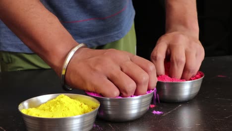 colorido holi | mano humana no identificada colocando cuencos de polvo de color en una pantalla verde | video de holi para anuncios y publicidad |