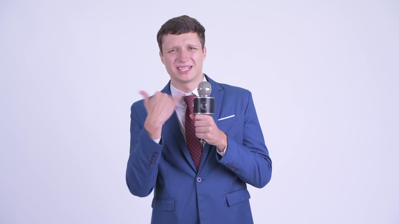 마이크를 든 슈트 입은 잘생긴 젊은 사업가