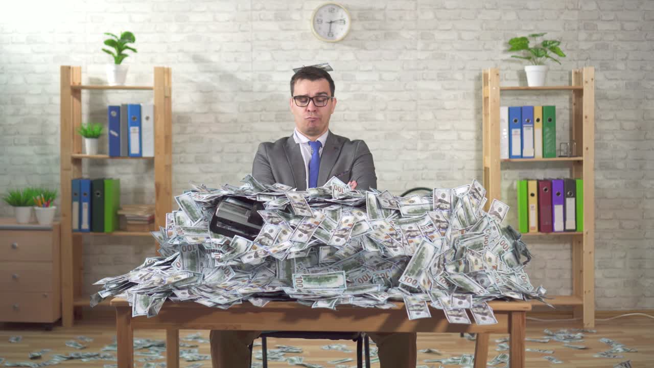 a serious man businessman in a pile of banknotes looks at the camera