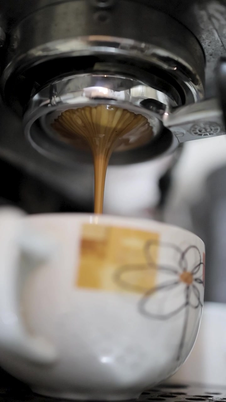 il caffè esce dalla macchina da caffè espresso nella tazza attraverso un portafiltro senza fondo