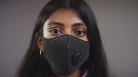 mujer joven con mascarilla para tirar del foco