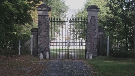 slow dolly towards large old closed gate of mansion castle