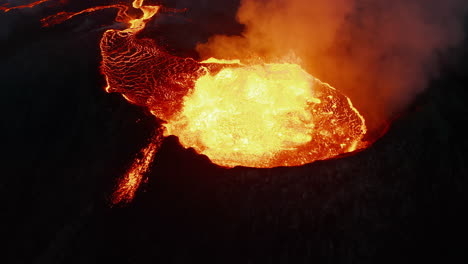 Crane-down-footage-of-boiling-magma-in-erupting-volcano-crater.-Lava-stream-flowing-down-on-slope.-Fagradalsfjall-volcano.-Iceland,-2021