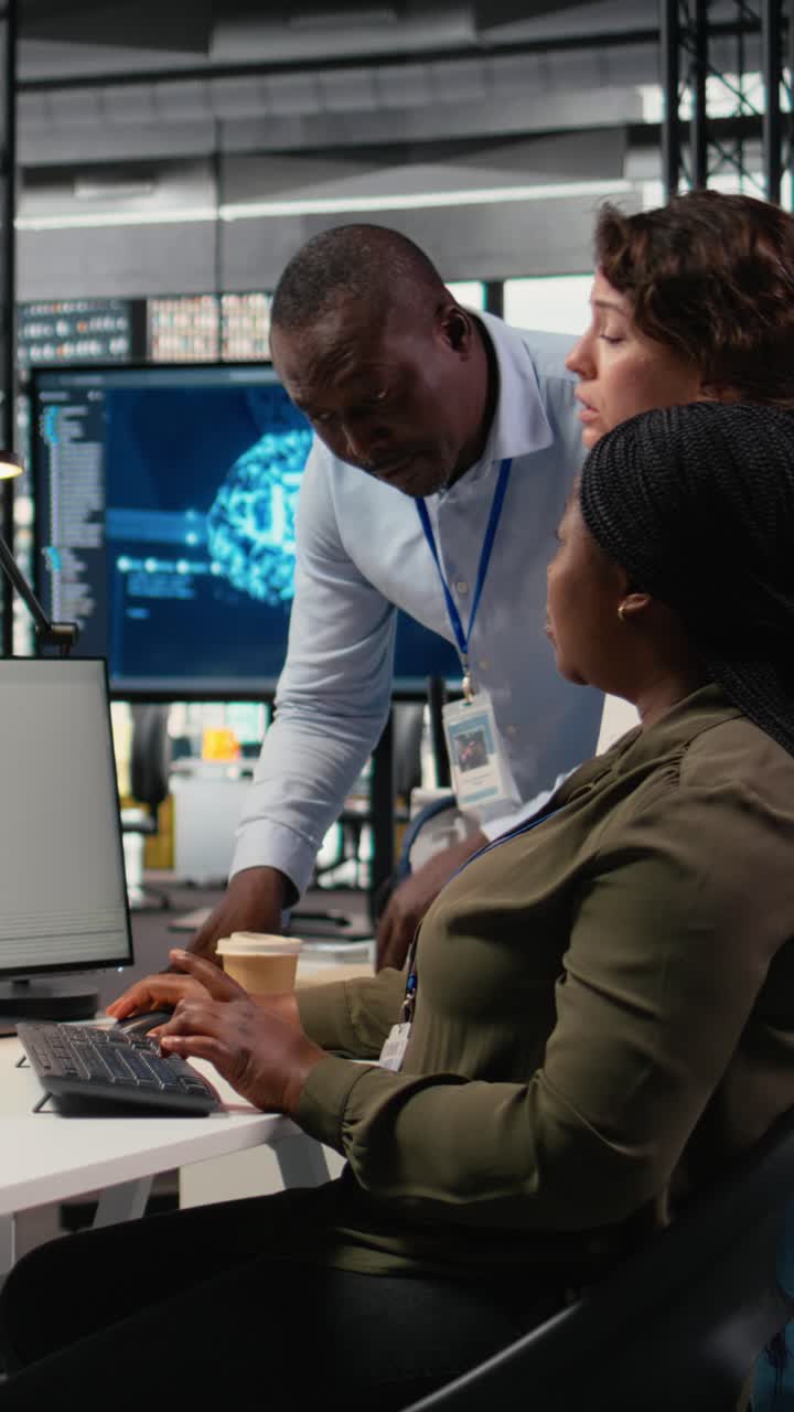Vertical video Team of technicians in office working together, automating workflows using AI