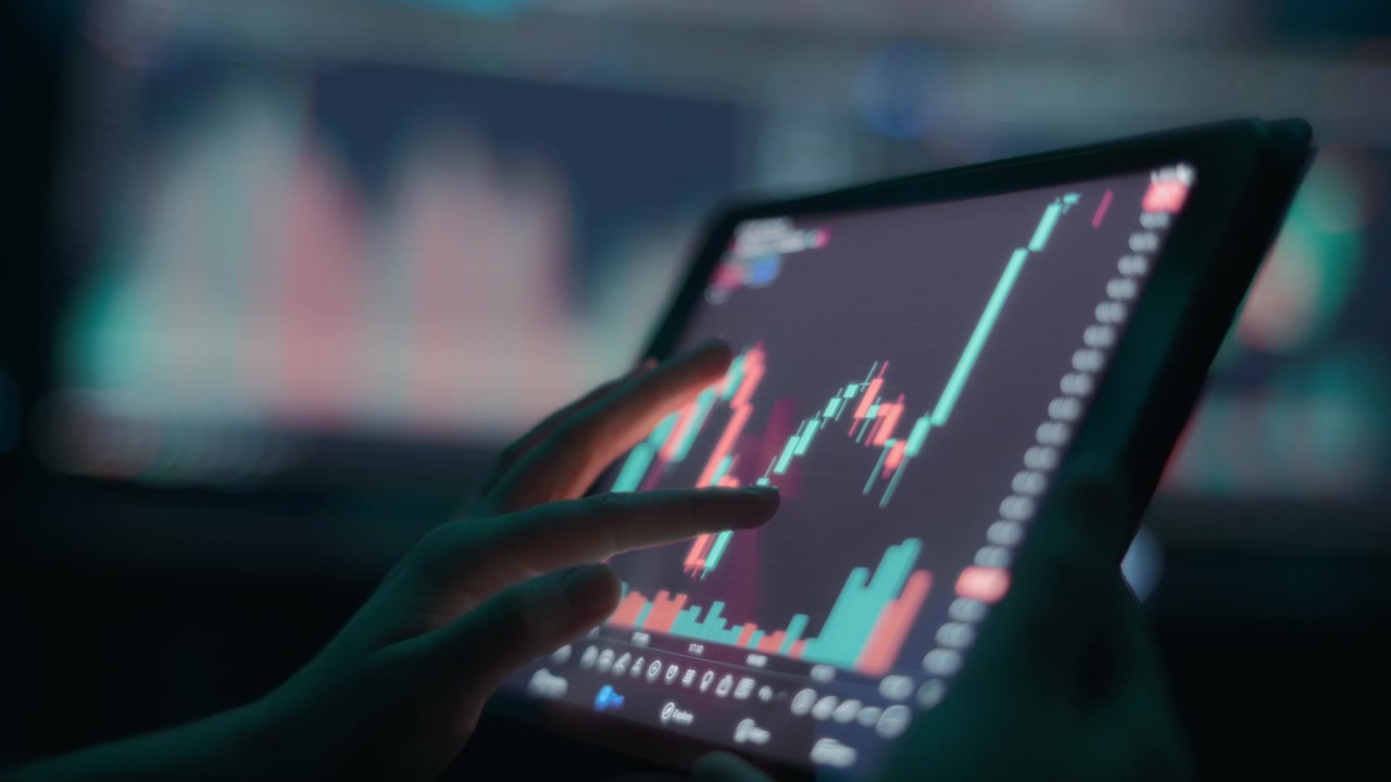Persona che analizza il grafico del mercato azionario su un tablet touchscreen