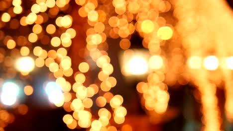 luces doradas borrosas festivas de las lámparas de la calle en la noche de navidad en la calle