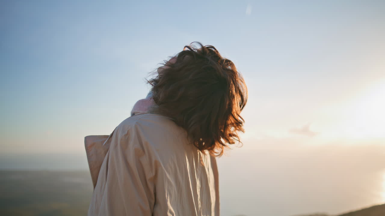mujer despreocupada girando camino costero al atardecer expresando alegría vibrante primer plano