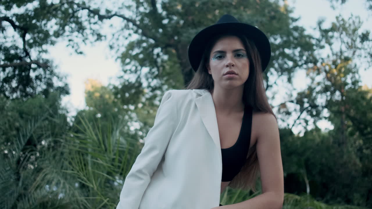 젊은 소녀 모델이 배경에 식물과 함께 포즈를 취하고 있습니다.