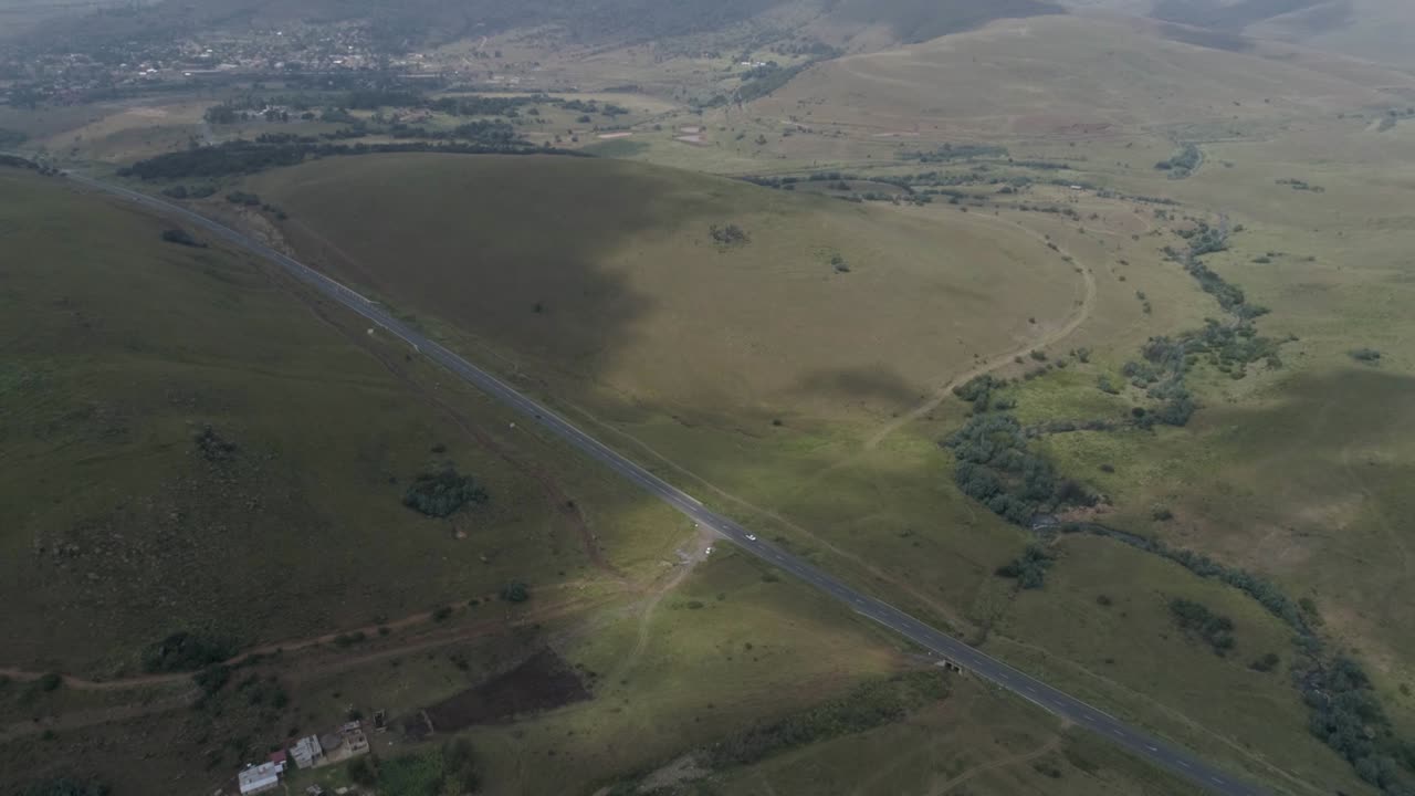 Aerial view of the entrance road to Machadodorp, in South Africa, with a small road and hills covered with vegetation