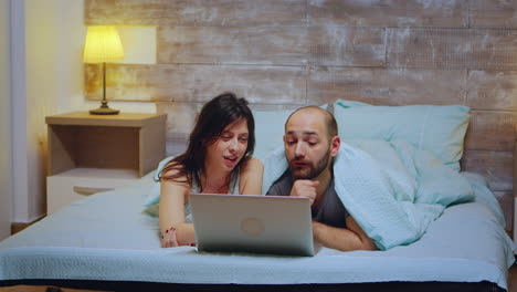 pareja con pijama acostada en la cama