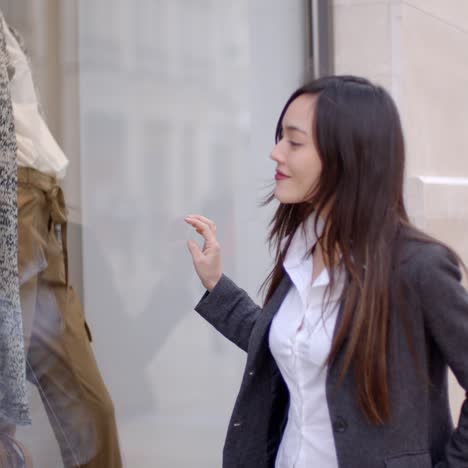 young woman looking at a shop mannequin