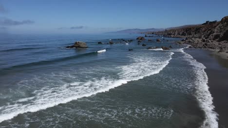 4k aerial drone footage over beach waves in northern california blue skies