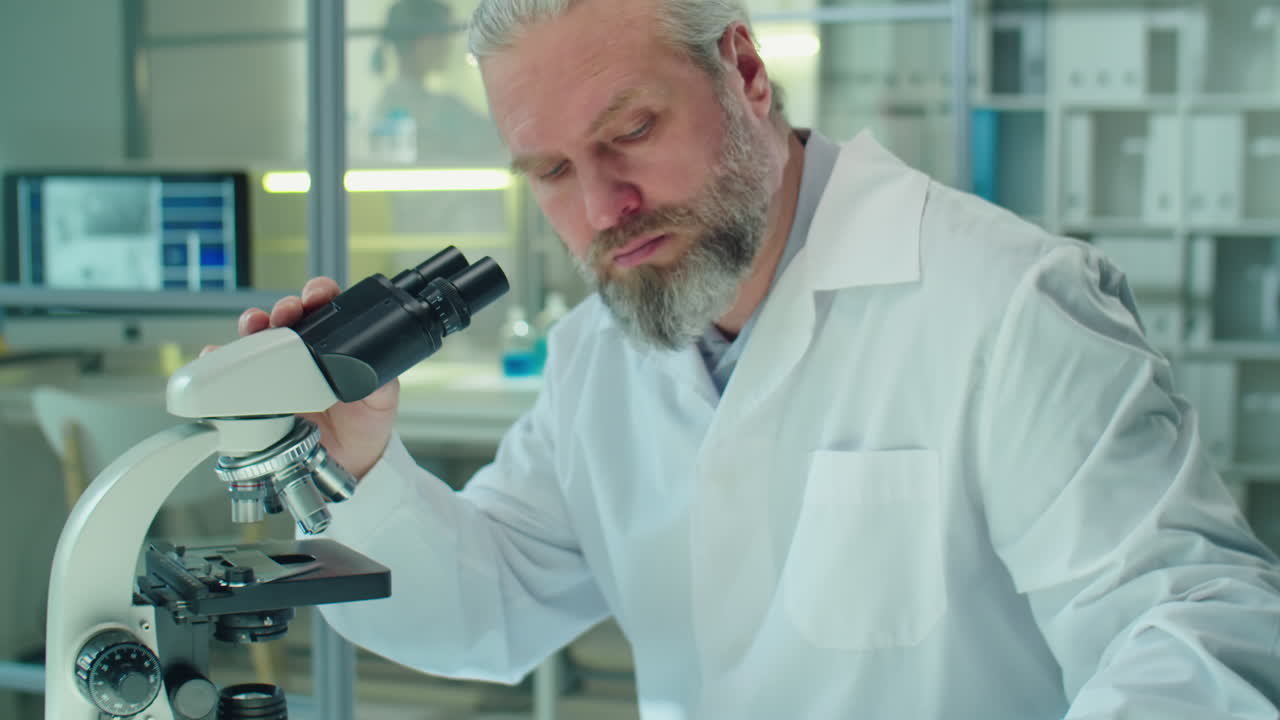 Senior Scientist Using Microscope in Lab
