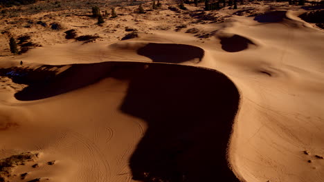 the drone’s straight-down angle reveals abstract shapes and stunning hues across pink dunes in utah’s south.