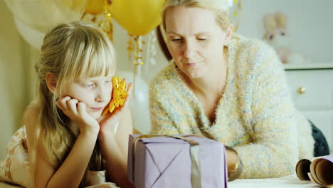 mom and daughter are packing presents together happy family activity with a child