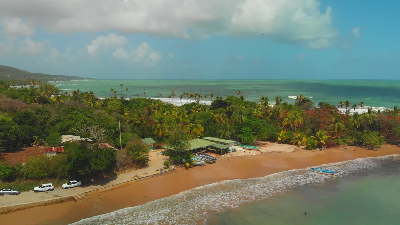 L'Oceano Atlantico sullo sfondo e il deposito di pesca di Balandra in primo piano con onde che si infrangono sulla riva a Trinidad e Tobago.
