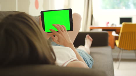 mujer usando tableta en el sofá