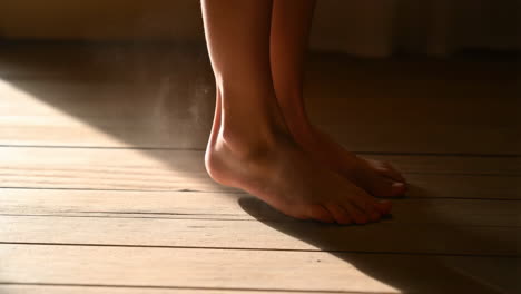child's bare feet on a wooden floor bathed in sunlight