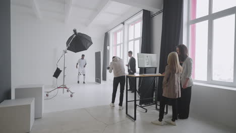 team is photographing afro-american football champion for magazine and ad campaign in studio