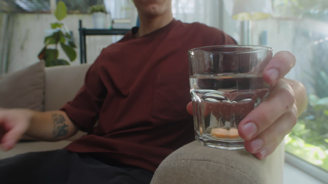 Person Placing Effervescent Tablet in Water