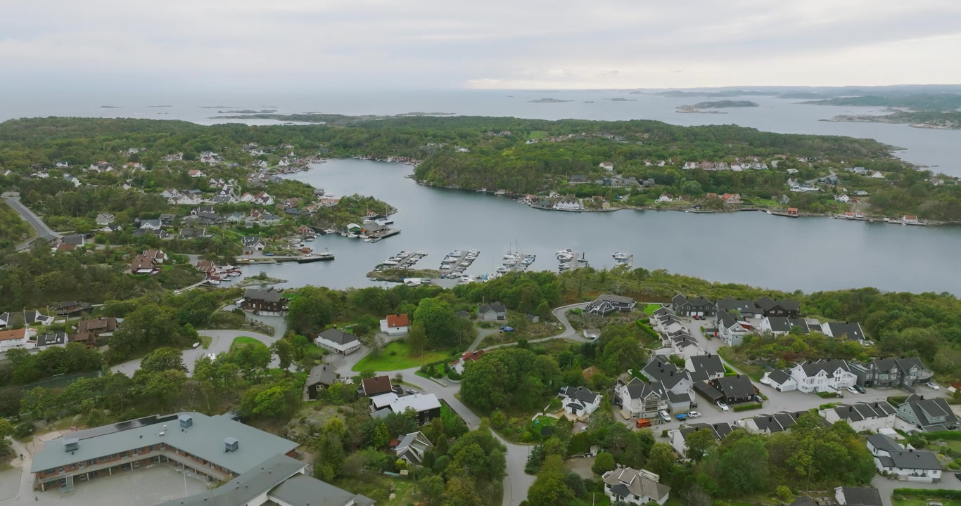 Veduta aerea di un villaggio sul lungomare a Flekkerøy, Kristiansand, Norvegia, in slow motion, che mostra le case affacciate sull'acqua