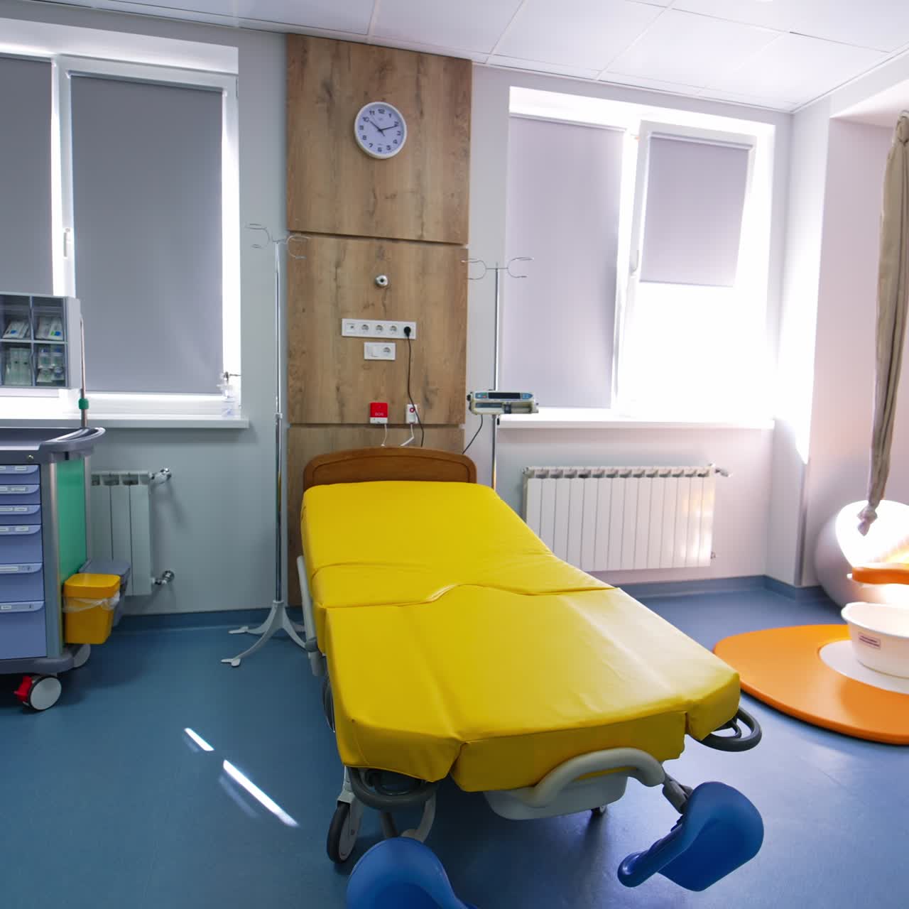 Bright yellow bed for deliveries in the maternity hospital. Spacious ward with new equipment in the modern clinic