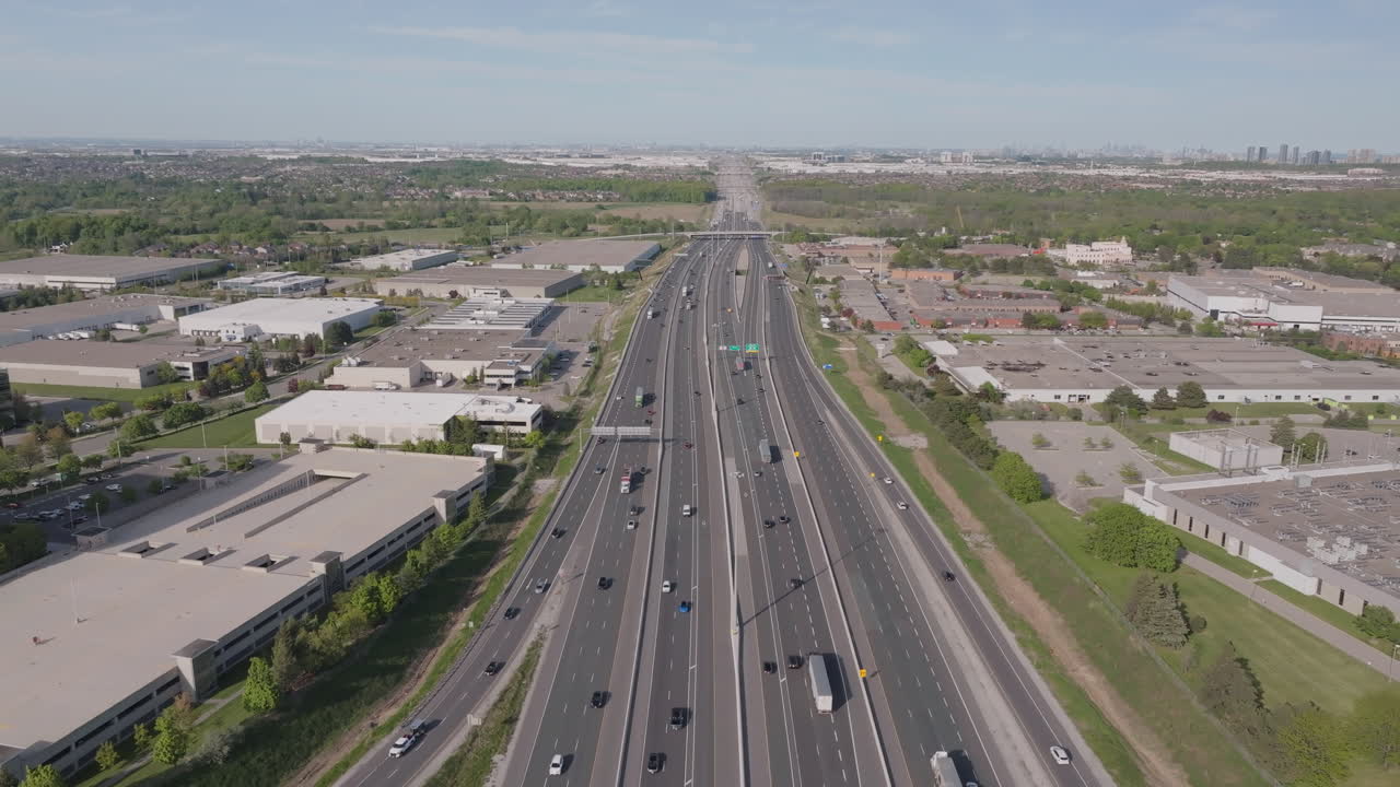 Wide aerial view of Highway 401 in Mississauga, showcasing a busy highway and industrial area