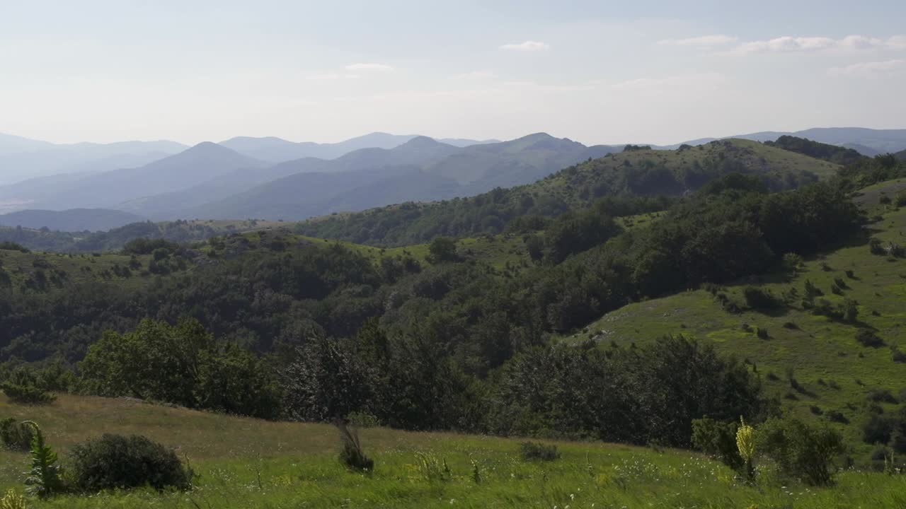 Panorama mozzafiato con dolci colline e rigogliose valli verdi sotto un cielo azzurro. Scena tranquilla che infonde un senso di calma. Apprezzamento per la natura. Stara Planina vicino alla città di Sliven. Monti Balcani