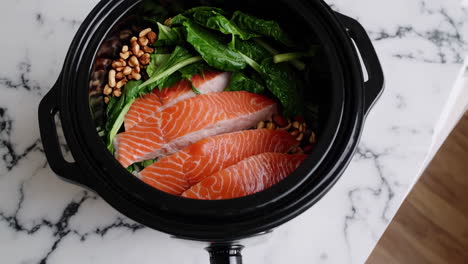 salmon with spinach and pecans in a slow cooker