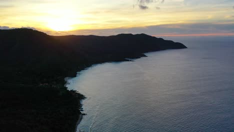 dramatic aerial shot captures st. croix’s island point silhouetted against a colorful sky filled with deep tropical hues, while calm ocean waters shimmer beneath the glowing clouds