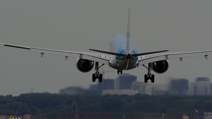 Airplane Landing on Runway with City Skyline in Background