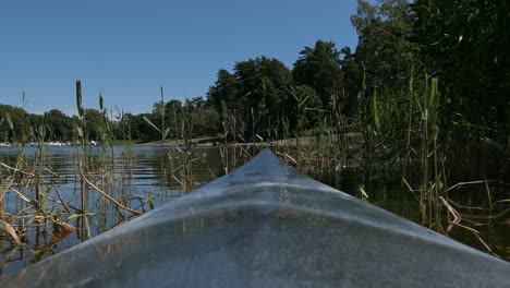 Kayaking-through-reeds-on-calm-water,-kayak-bow-point-of-view