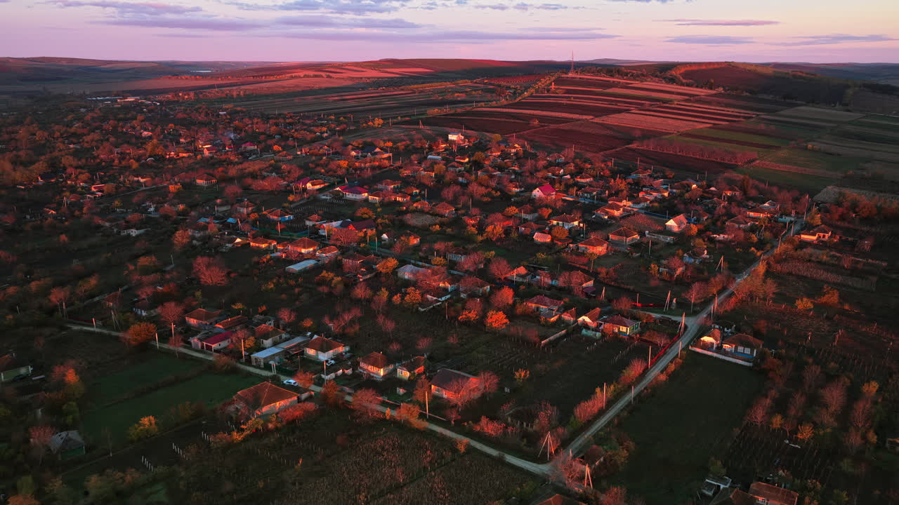 Aerial drone view of a Moldovan village illuminated by warm golden hour sunlight