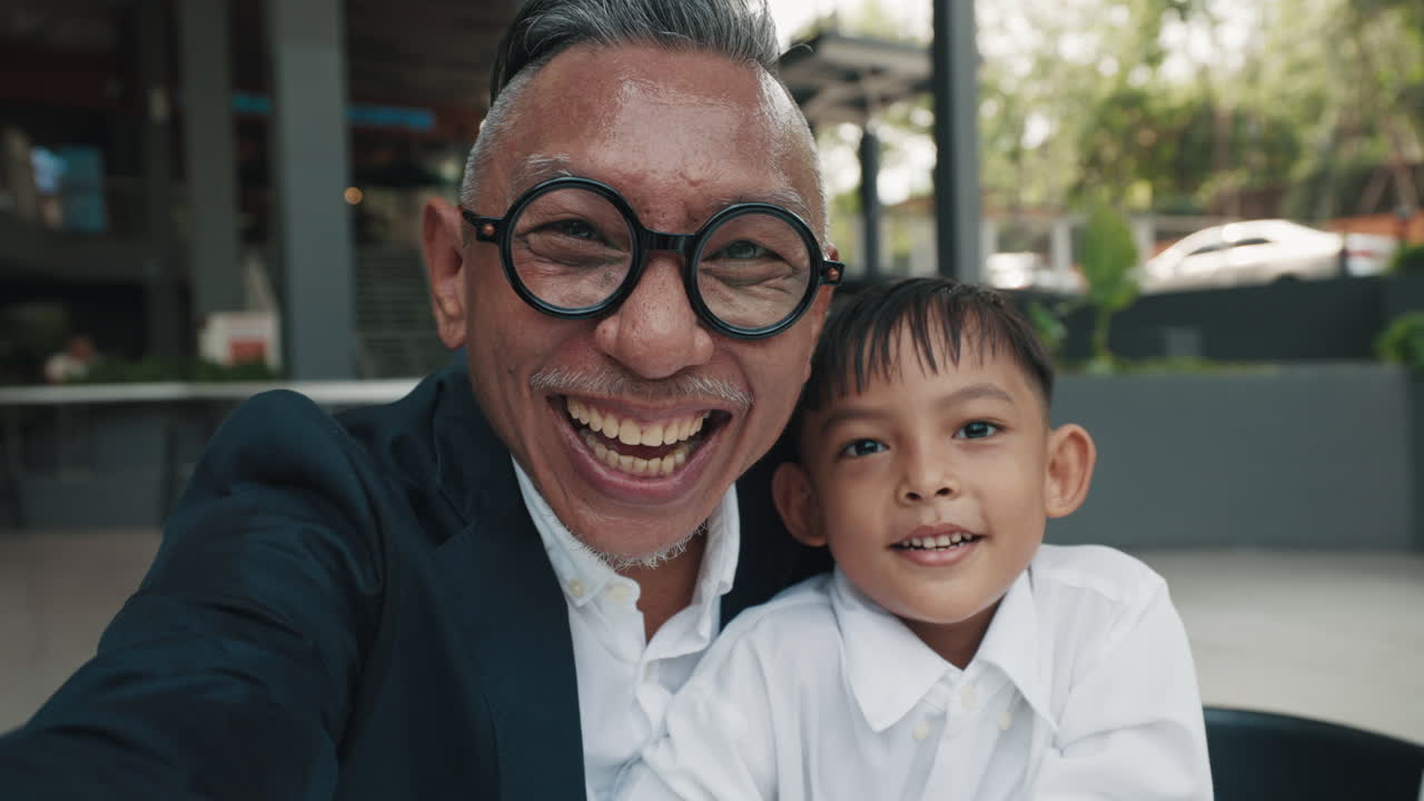 A happy grandfather and grandson taking a selfie together