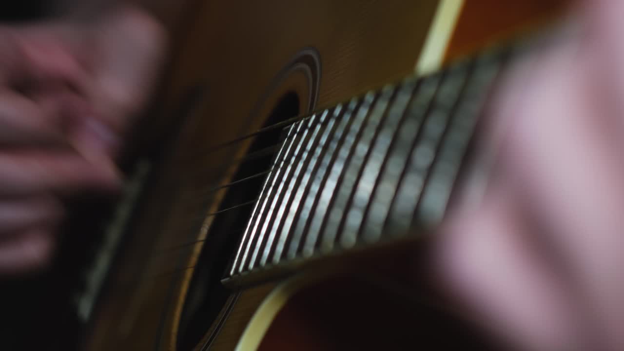 Close-up of hands playing acoustic guitar