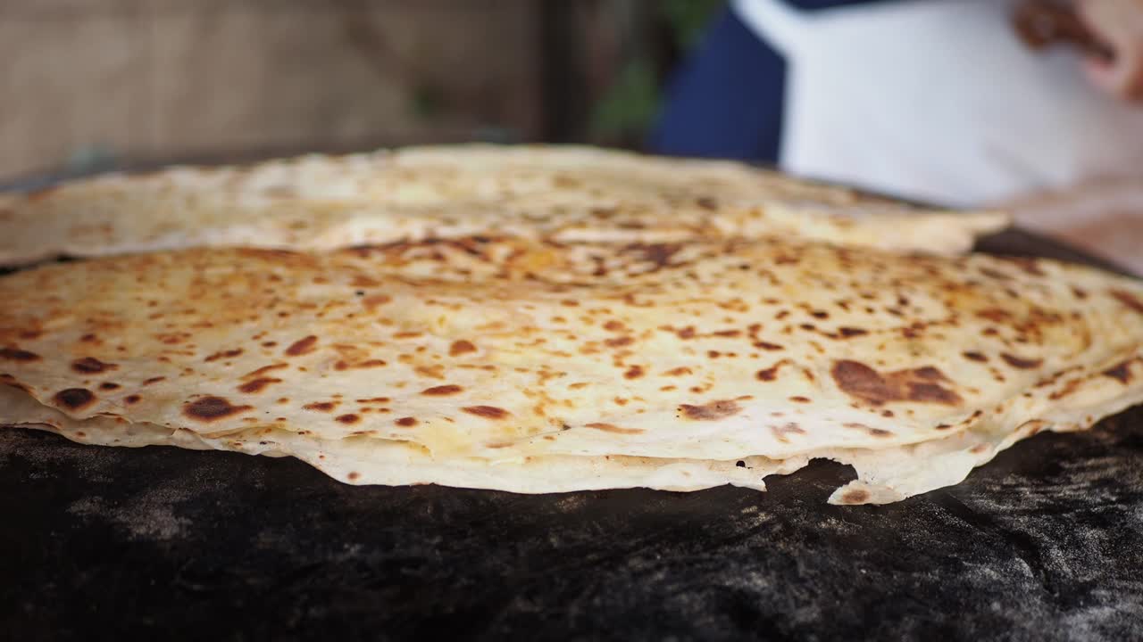 Nærbilde av en Gozleme, et tyrkisk flatbrød, som stekes på en varm takke