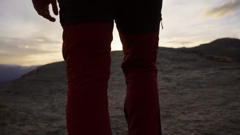 silhouette of hiker at sunset on rocky hilltop in norway, calm and scenic moment, trolltunga